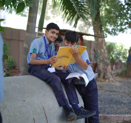 Students Reading Books Together Outdoors on Campus