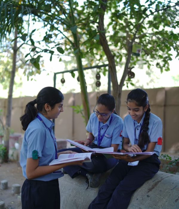 School Students Reading Books Together Outdoors in Campus Courtyard
