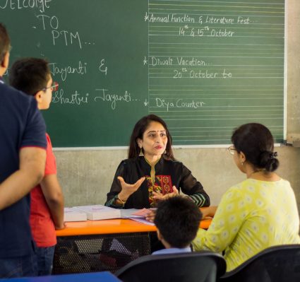 Teacher Interacting with Parents and Students During Parent-Teacher Meeting